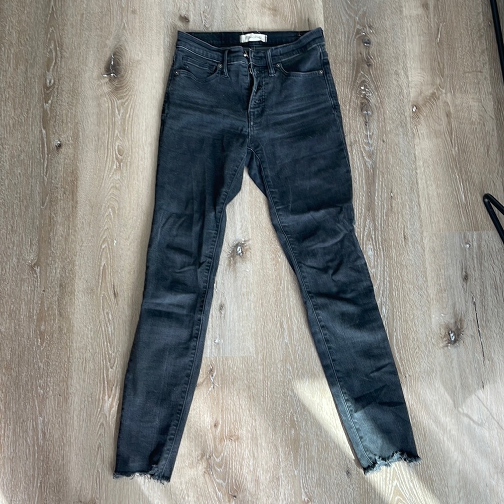 Black skinny jeans with distressed hem.